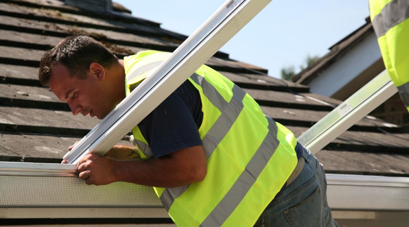 Window Wise installer in high-vis vest carefully aligning roof struts. 