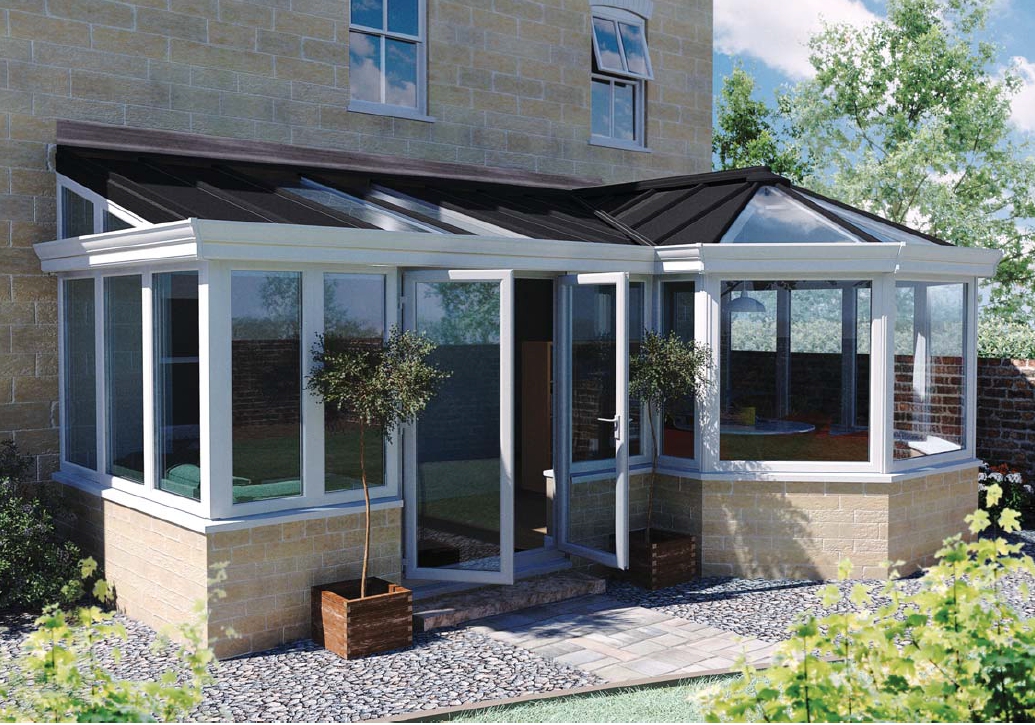 An orangery with a sandstone style base to match the house fabrication, featuring a part glazed roof facing a garden in lovely weather.