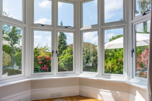 A bay window seen from the inside looking over a pretty garden, the windows are constructed in high quality PVCu, with robust handles.