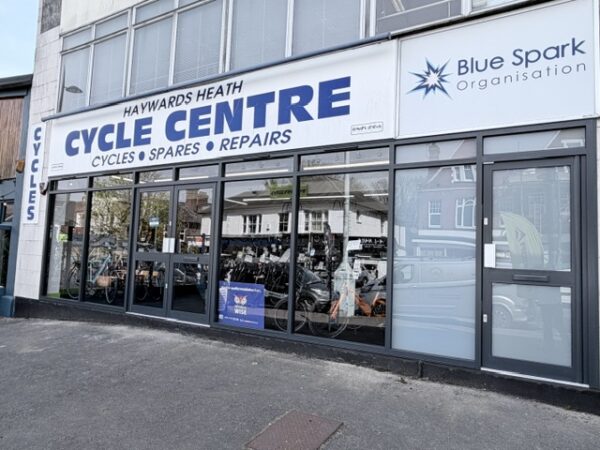 Haywards Heath Cycle Centre and Blue Spark Organisation shopfronts showing the completed windows and doors looking crisp and new with a Window Wise sign on display. 