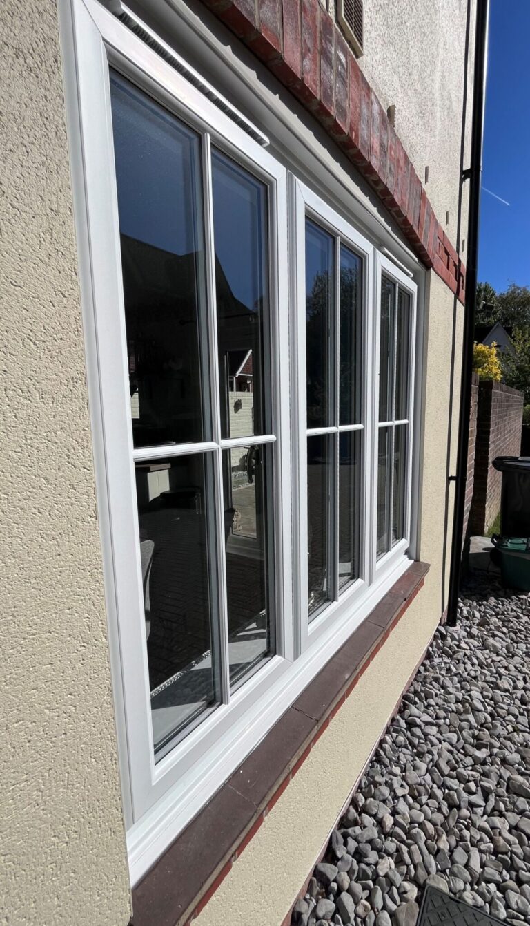 Close-up view of new PVCu sliding sash windows with surface-mounted astragal bars.