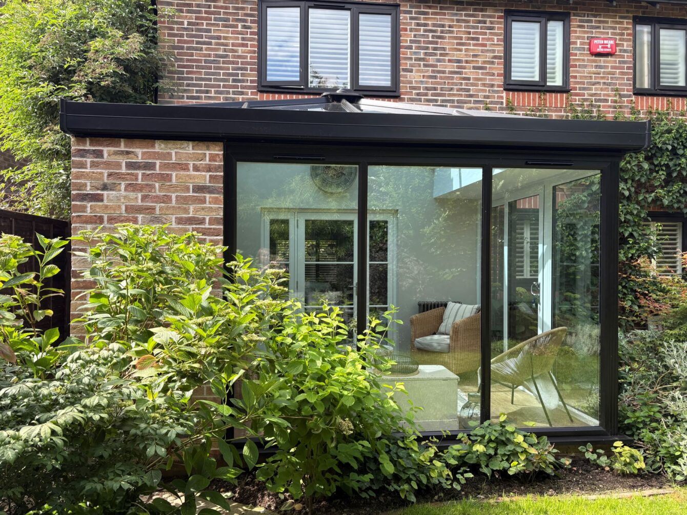 Outside of the hup! extension looking in towards the internal French doors, the matching brick slips and window frames can be clearly seen.